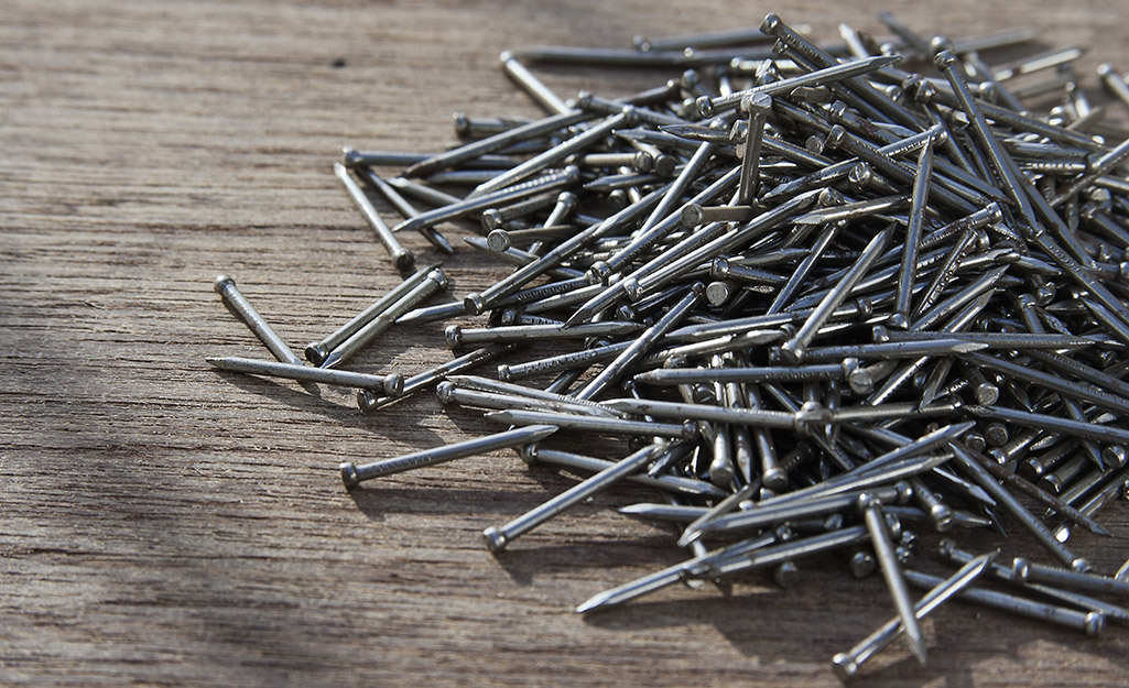 group shot of various nails piled up on timber boards