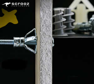 an anchor fastener fixed into a piece of plasterboard